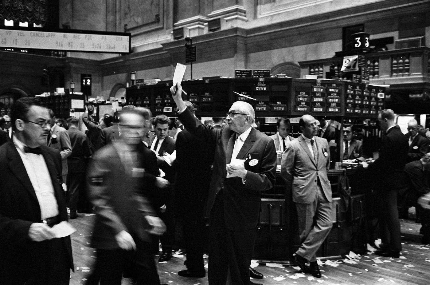 A busy trading floor with brokers crowded around workstations at the New York Stock Exchange